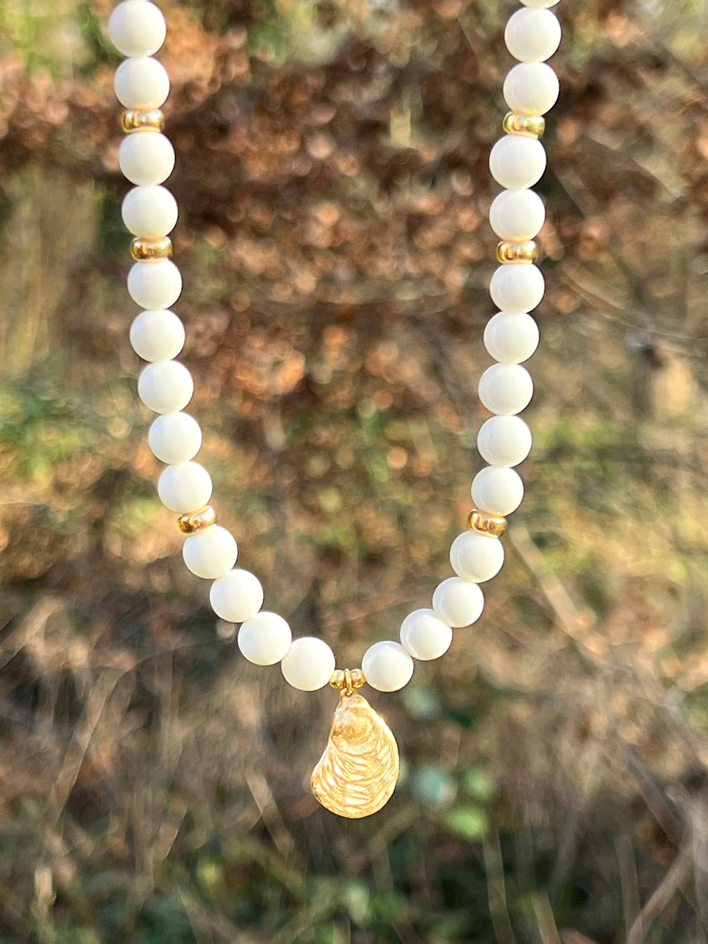 White bead necklace with golden sea shell charm